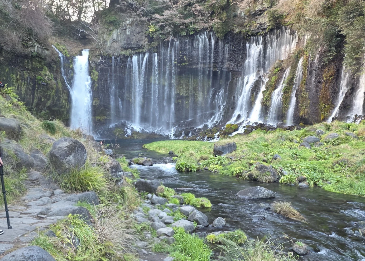 Multiple streams of Shiraito Falls flowing down the cliff into the valley in Fujinomiya