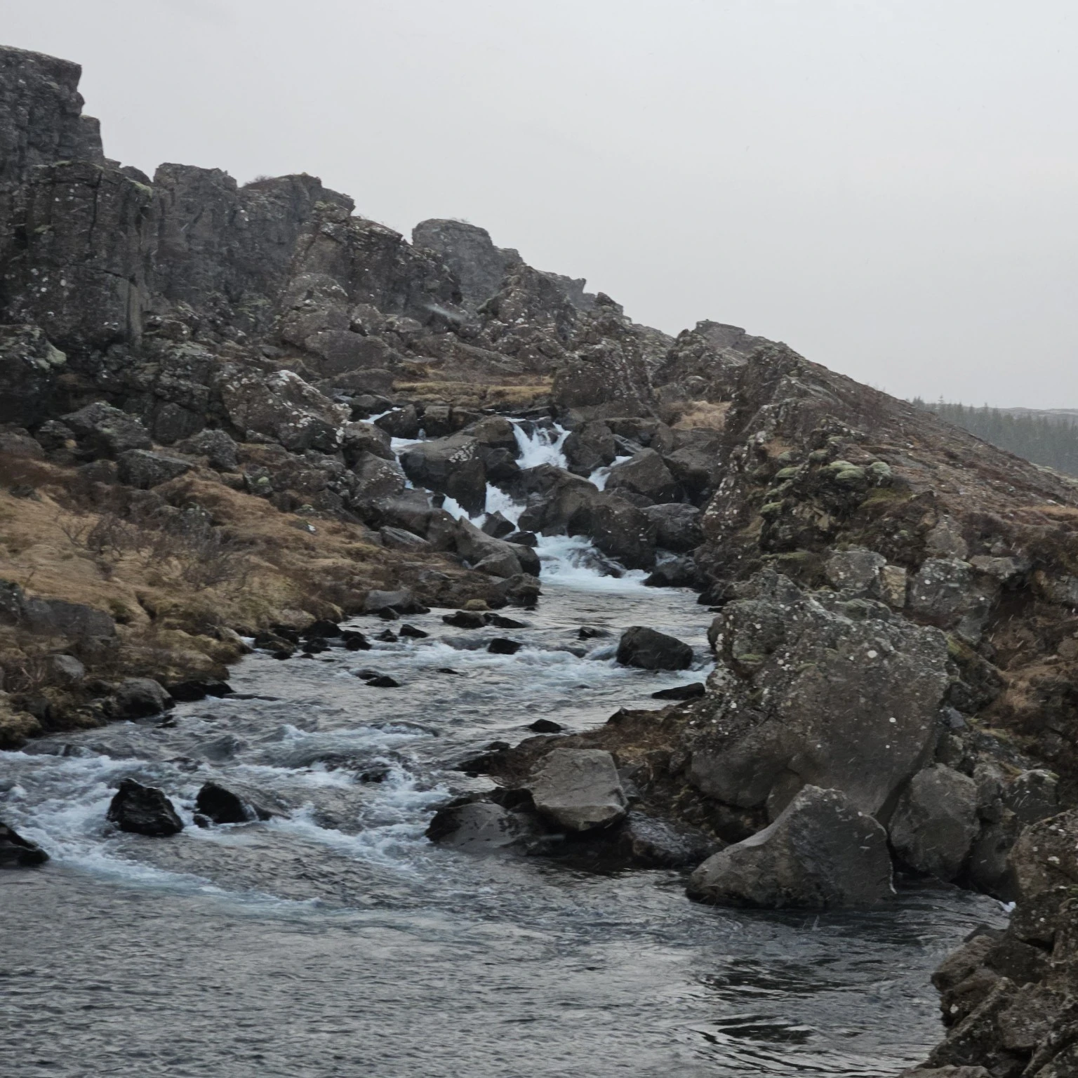 The Öxará river moving between dark rocks near Öxarárfoss